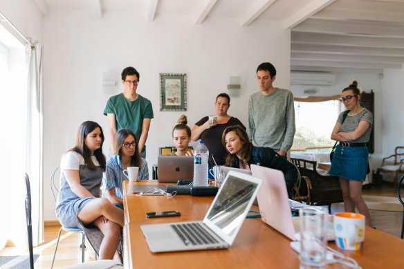 Group of people behind a laptop